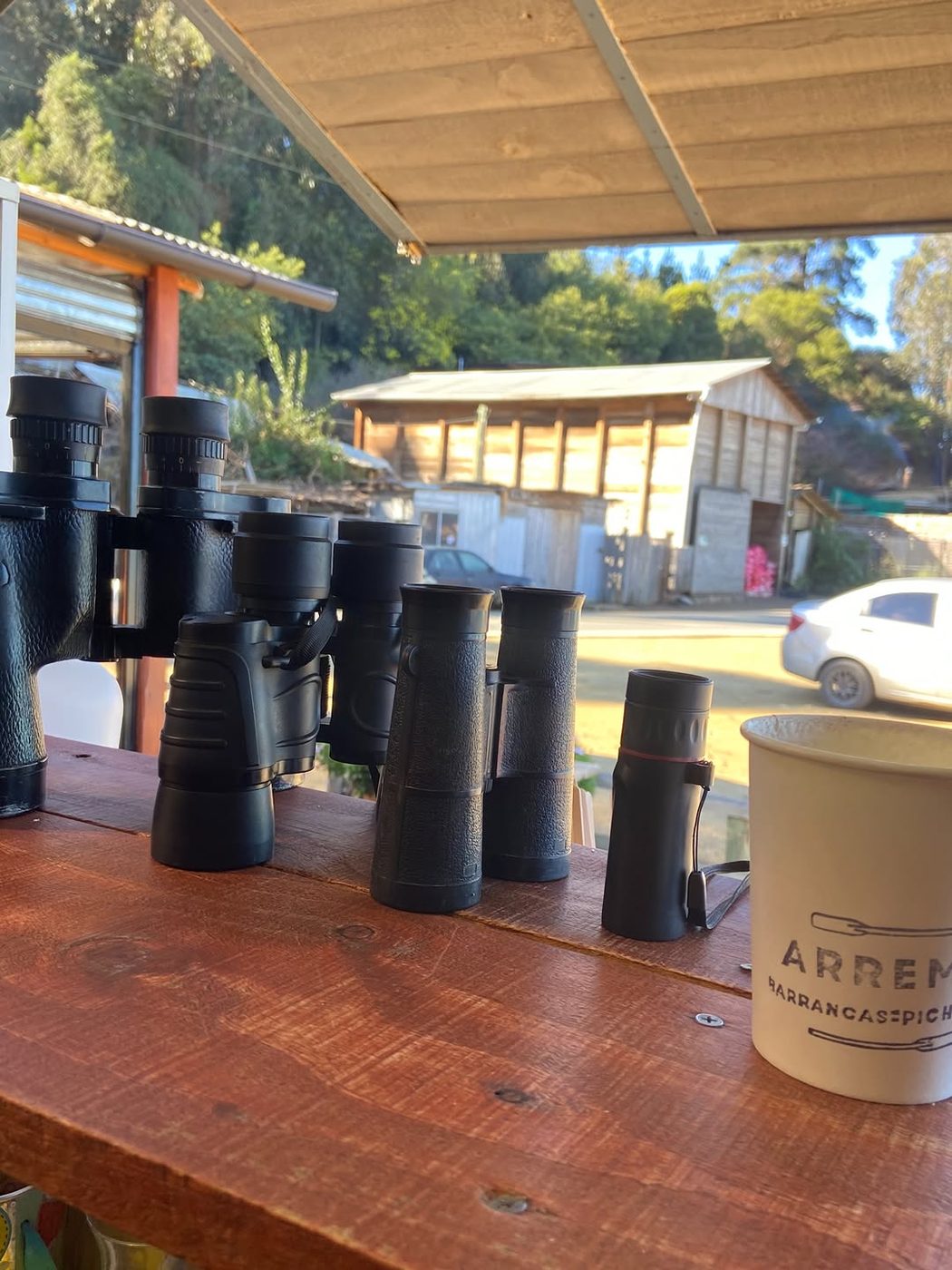 Binoculares sobre el mesón de ARREMO junto a un vaso de café